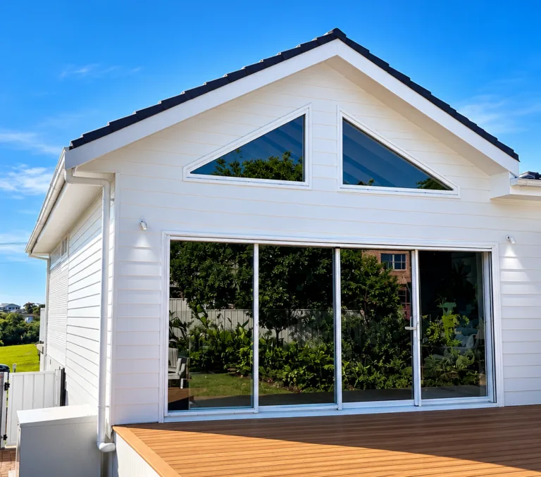 The same extension completed, with white cladding and glass doors onto the deck